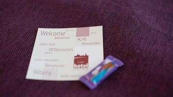 A welcome card with multilingual greetings and a hotel logo.