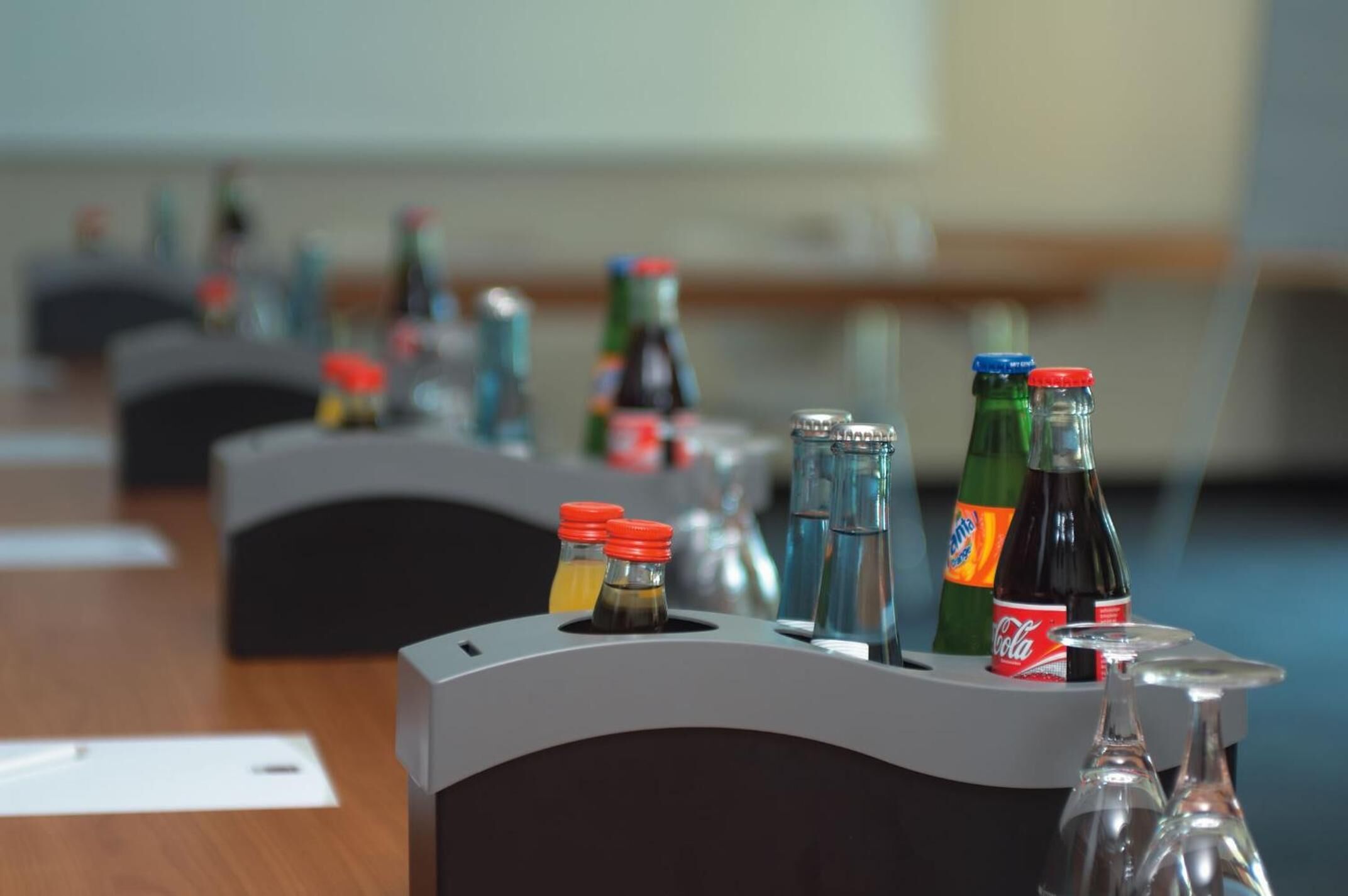 A conference table with multiple bottles of beverages and glasses, likely for a meeting or event.