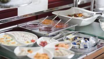 A buffet with various dishes and condiments.