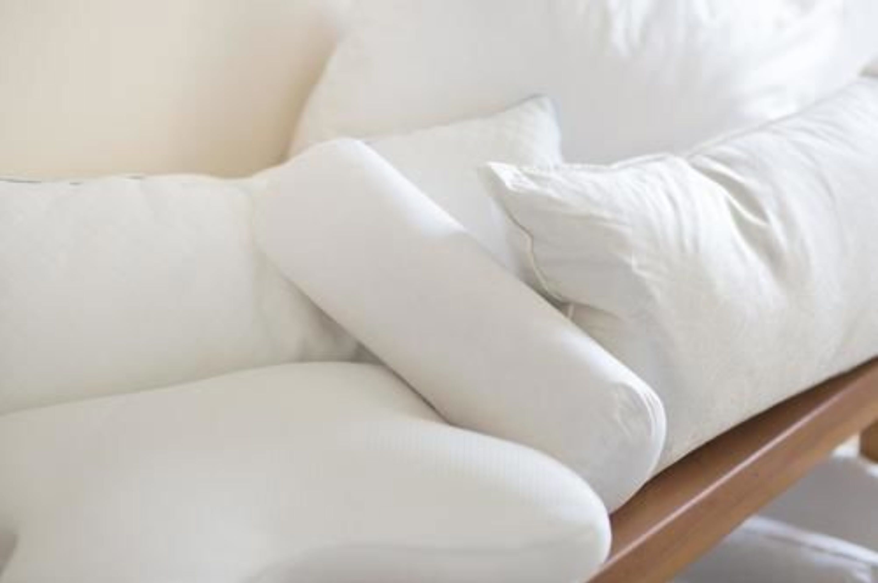 A white upholstered chair with a wooden frame.
