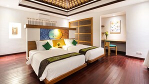 A hotel room with two beds, a desk, a chair, a ceiling fan, and artwork on the walls. - Sunset Paradise Villa Jimbaran 3003 (Kedonganan)