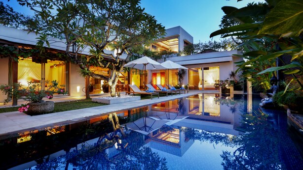 A modern resort with a swimming pool, lounge chairs, and a well-maintained garden. - Sunset Paradise Villa Jimbaran 8008 (Kedonganan)