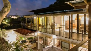 A modern house with a pool, large windows, and outdoor seating. - Sunset Paradise Villa Temple Hill (Jimbaran)