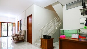 A spacious hallway with a staircase, a wooden desk with a computer, and a chair. - Casa Sidoluhur 17 (Surabaya)