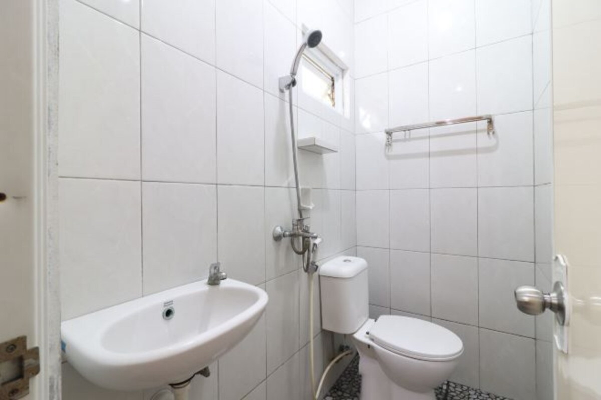 A bathroom with a white sink, toilet, and shower.
