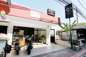 Un escaparate con un letrero que dice 'DOKTER CIGI H. ABD. AZIS' y una motocicleta estacionada afuera.