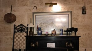 A room with a piano, a framed painting, and a checkered wall pattern. - El Palacil (Velez-Blanco)