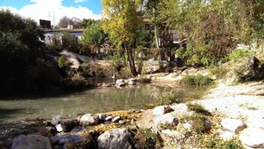 Paisaje natural con un río, rocas y árboles.