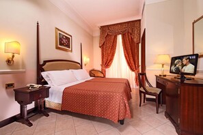 A hotel room with a bed, bedside tables, a TV, a desk, and a chair. - Hotel Nizza (Roma)