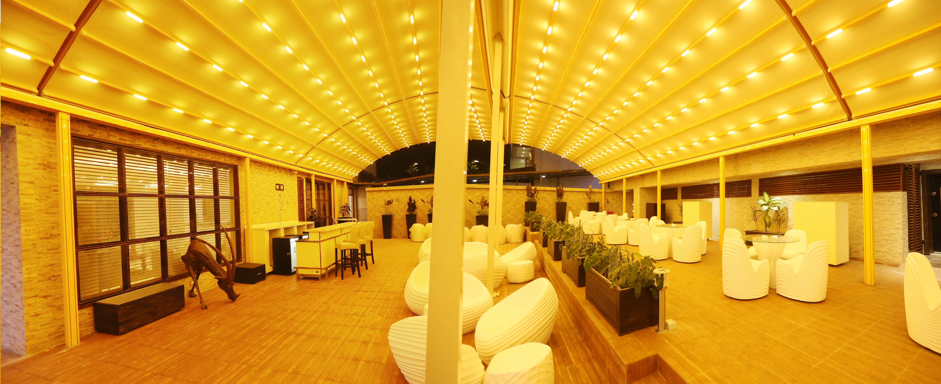 A spacious indoor area with a high ceiling, multiple seating arrangements, and a reception desk.
