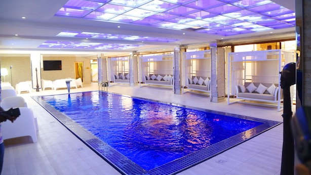 Una piscina interior con suelo de baldosas y techo con diseño de cuadrícula.
