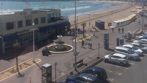 Une ville côtière dotée d’une plage, d’un parking et d’un bâtiment portant l’inscription « AL NOIO ».