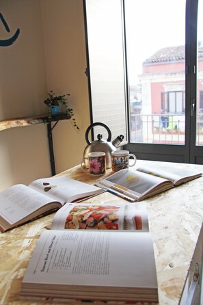 A table with open books, a kettle, and a mug. - Urban Pop Hostel & BnB (Catania)