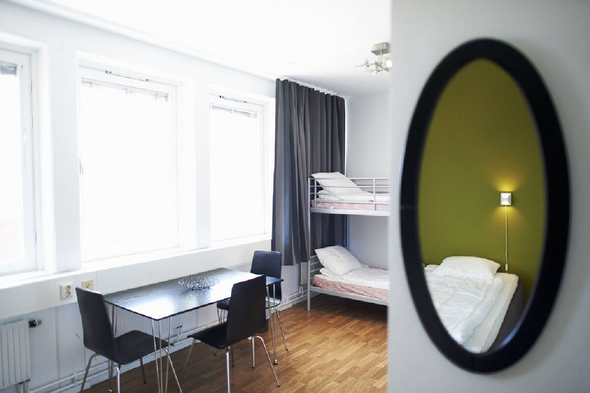 Een slaapzaal met stapelbedden, een bureau en een stoel.