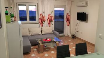 Familieleilighet, 2 dobbeltsenger, ikke-røyk, sjøutsikt | Oppholdsrom | Flatskjerm-TV og DVD-spiller