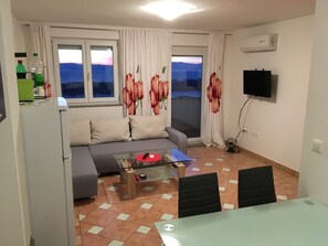 Familieleilighet, 2 dobbeltsenger, ikke-røyk, sjøutsikt | Oppholdsrom | Flatskjerm-TV og DVD-spiller