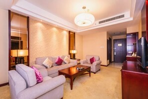 A hotel room with a sofa set, a coffee table, a TV, and a lamp. - Tiangui Zhongzhou International Hotel (Neixiang)