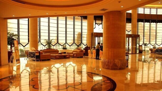 A spacious lobby with a polished floor, large windows, and a central seating area. - Tiangui Zhongzhou International Hotel (Neixiang)
