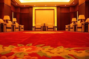 A conference room with a large carpet, a central table, and chairs arranged around it. - Tiangui Zhongzhou International Hotel (Neixiang)
