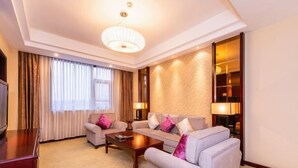 A hotel room with a sofa set, a coffee table, a TV, and a large window with curtains. - Tiangui Zhongzhou International Hotel (Neixiang)