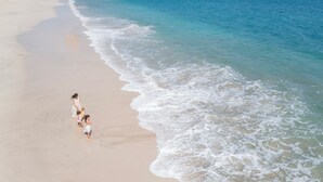 Escena de playa con arena y olas suaves.
