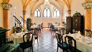 A dining area with tables set for service, arched ceilings, and a chandelier. - Schlosshotel Zum Markgrafen (Quedlinburg)