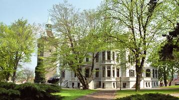 A large, historic building with a prominent tower and multiple windows.
