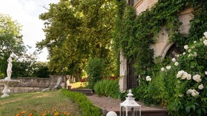 A garden with a statue, a white lantern, and a stone wall. - Schlosshotel Zum Markgrafen (Quedlinburg)