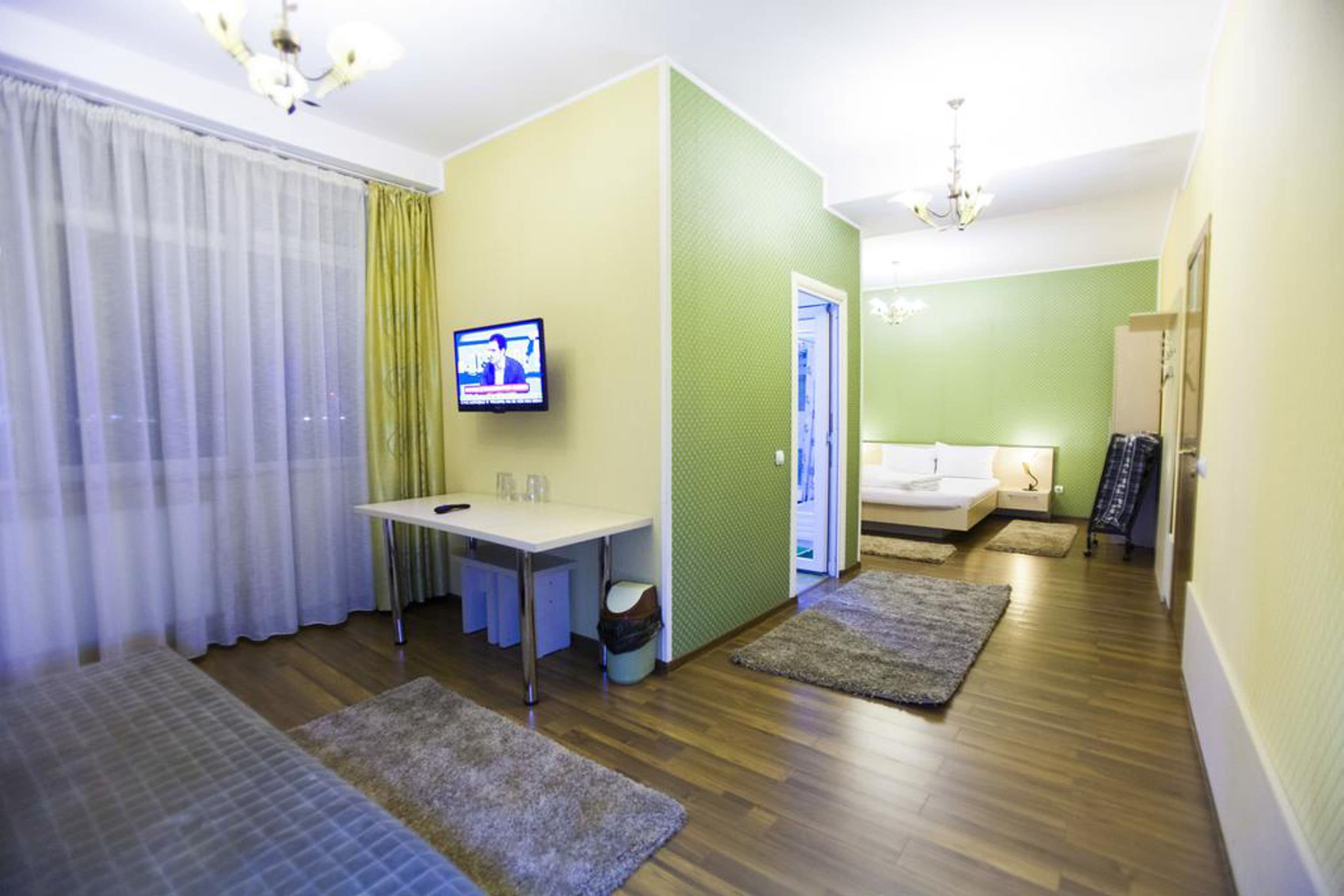 Een hotelkamer met een bed, een bureau, een televisie en een zithoek.