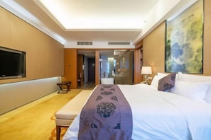 A hotel room with a large bed, a flat-screen TV mounted on the wall, a bedside table, and a large window. - Dynasun International Hotel (Nantong)