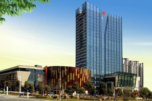 A modern building with a glass facade and a distinctive red and yellow striped structure nearby. - Dynasun International Hotel (Nantong)