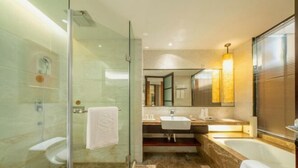 Un baño moderno con cabina de ducha de vidrio, bañera y tocador con espejo.