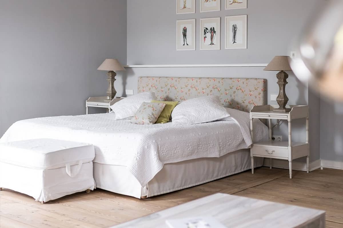 Une chambre à coucher bien rangée, avec un lit, des tables de chevet et une petite table de nuit.