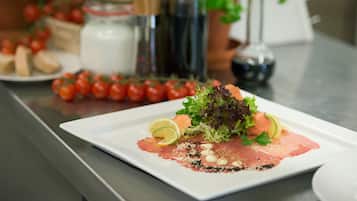 A plate of food with a salad, tomatoes, and a bottle of dressing.