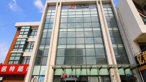 Un bâtiment moderne doté d’une grande façade en verre, d’une enseigne bien visible au sommet et d’une entrée clairement identifiable grâce à un rideau.