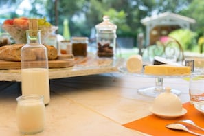 A breakfast table with milk, cheese, bread, and fruits. - La Maison de la Cigale (Forcalqueiret)