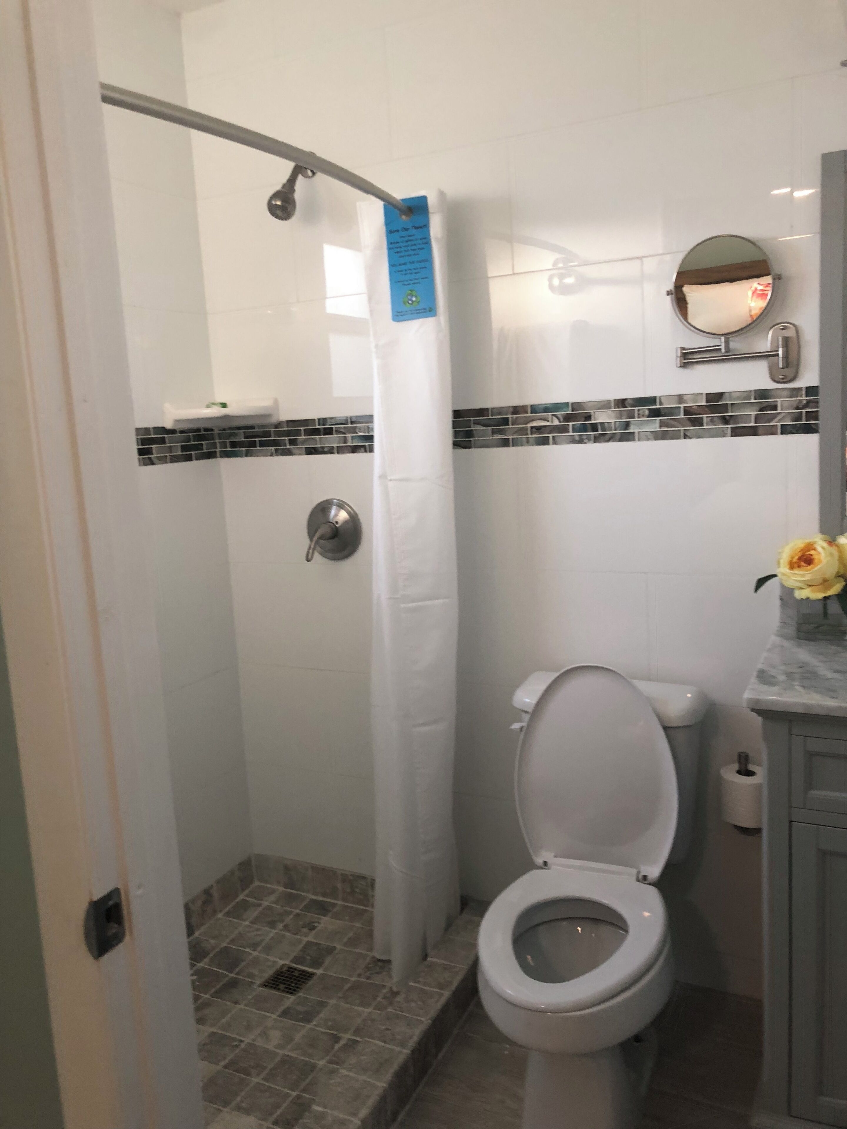 A bathroom with a shower, toilet, and sink.