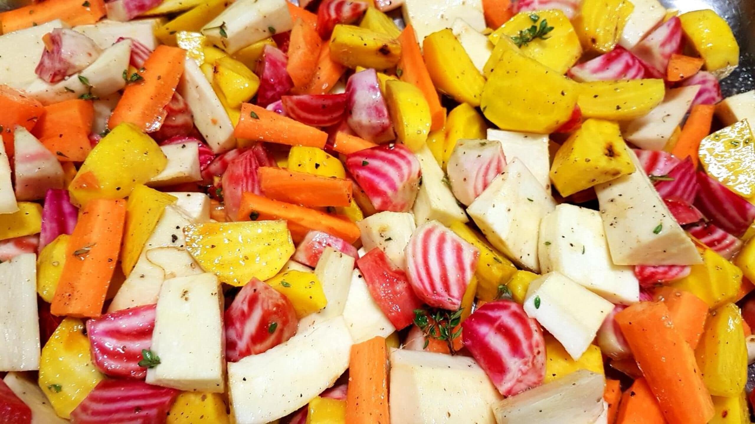 Um close-up de uma salada de legumes colorida, com diversos vegetais e ervas.