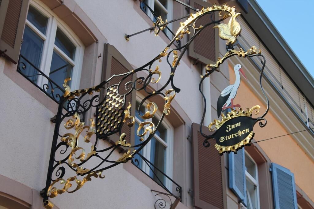 A building with a decorative sign featuring a stork and the text "Zum Storchen".
