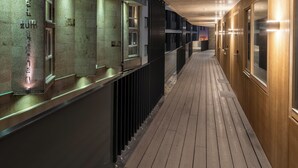 A corridor with wooden flooring and walls, featuring a series of rooms with windows and doors, and a visible sign that reads "HOTEL". - Restaurant Hotel Zum Storchen (Waldkirch)