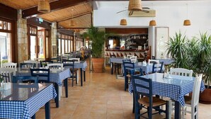 Un restaurante con manteles a cuadros, vigas de madera y plantas en macetas.