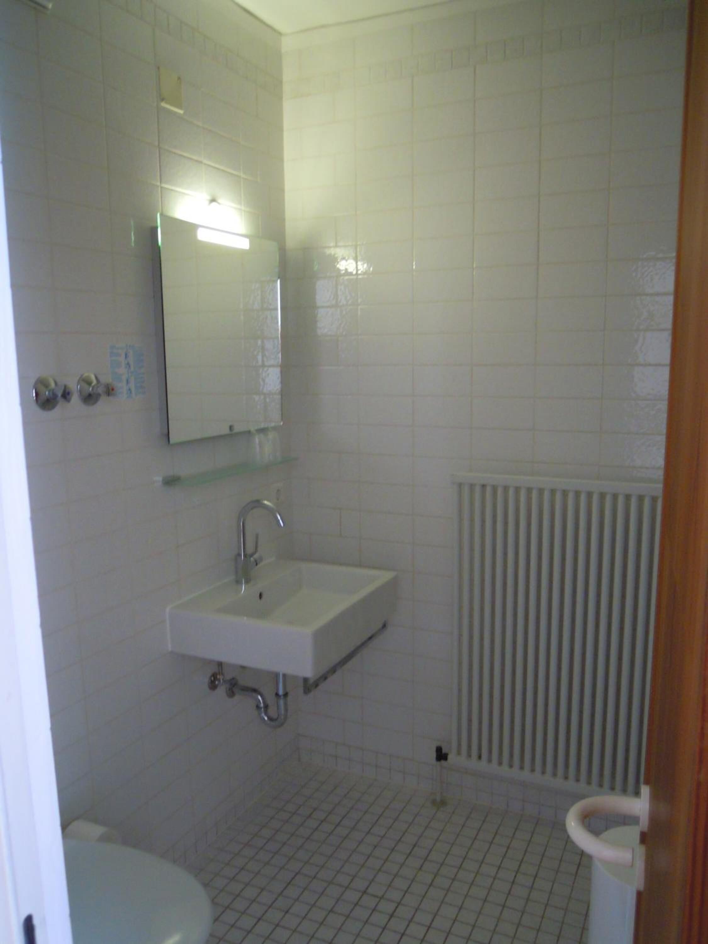 Ein Badezimmer mit Waschbecken, Spiegel und Toilette.