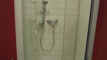 Un box de ducha con paredes de azulejos blancos y suelo blanco.
