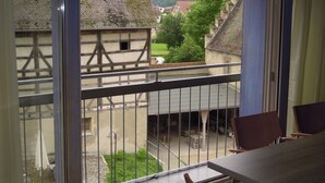 Ein Balkon mit Blick auf traditionelle Gebäude und eine grüne Landschaft.