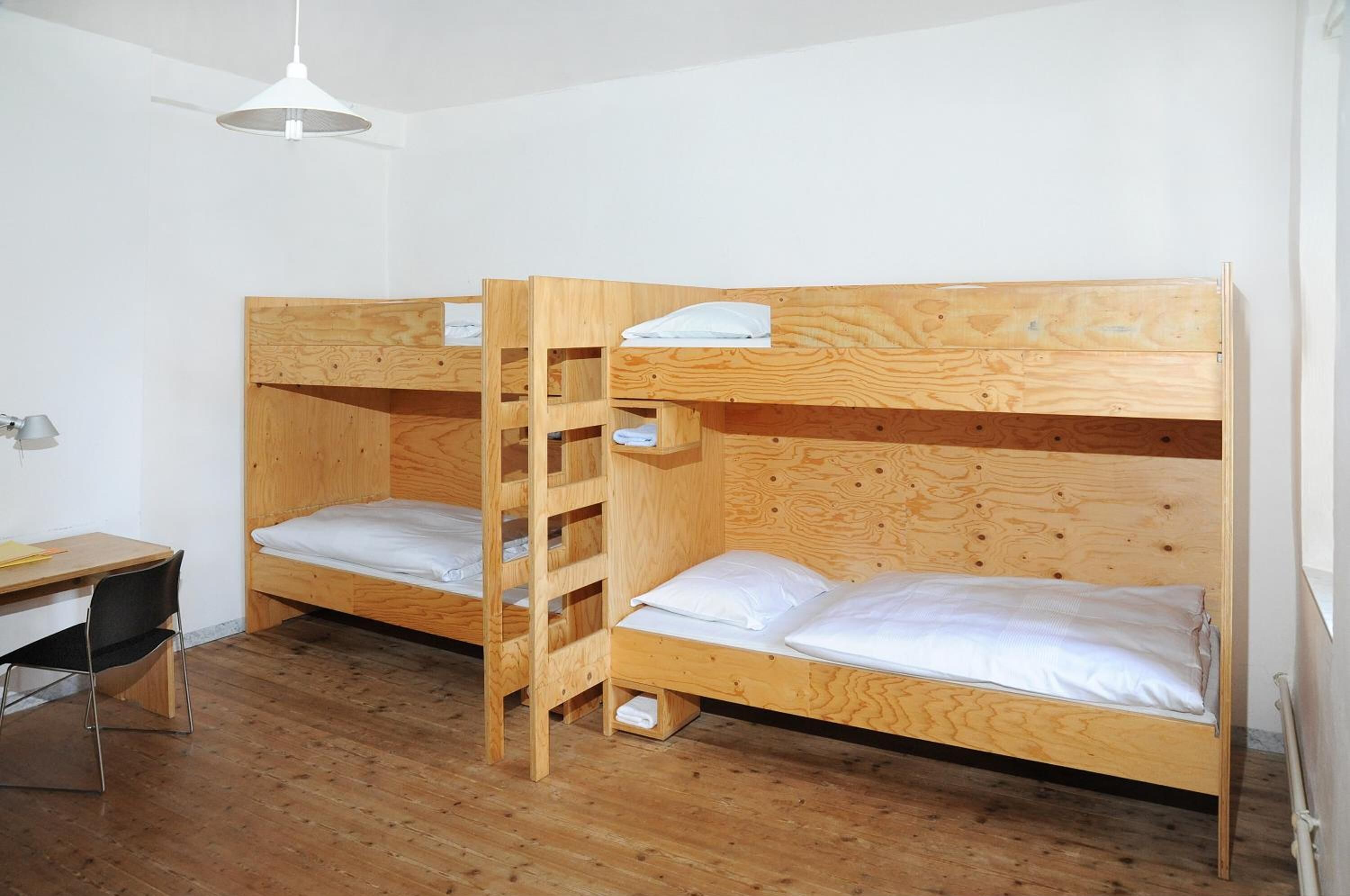 Un dormitorio con dos literas, un escritorio y una silla.