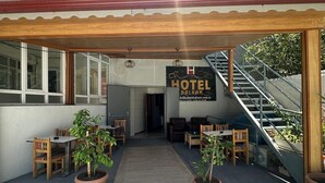 A hotel entrance with a covered patio, outdoor seating, and a staircase leading to an upper level. - BALKAN PALACE EDIRNE (Edirne)