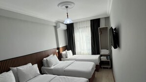 A hotel room with two beds, a ceiling fan, a mirror, and a wardrobe. - BALKAN PALACE EDIRNE (Edirne)