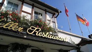 Un edificio con un letrero que dice 'Keller Restaurant' y banderas en la parte superior.