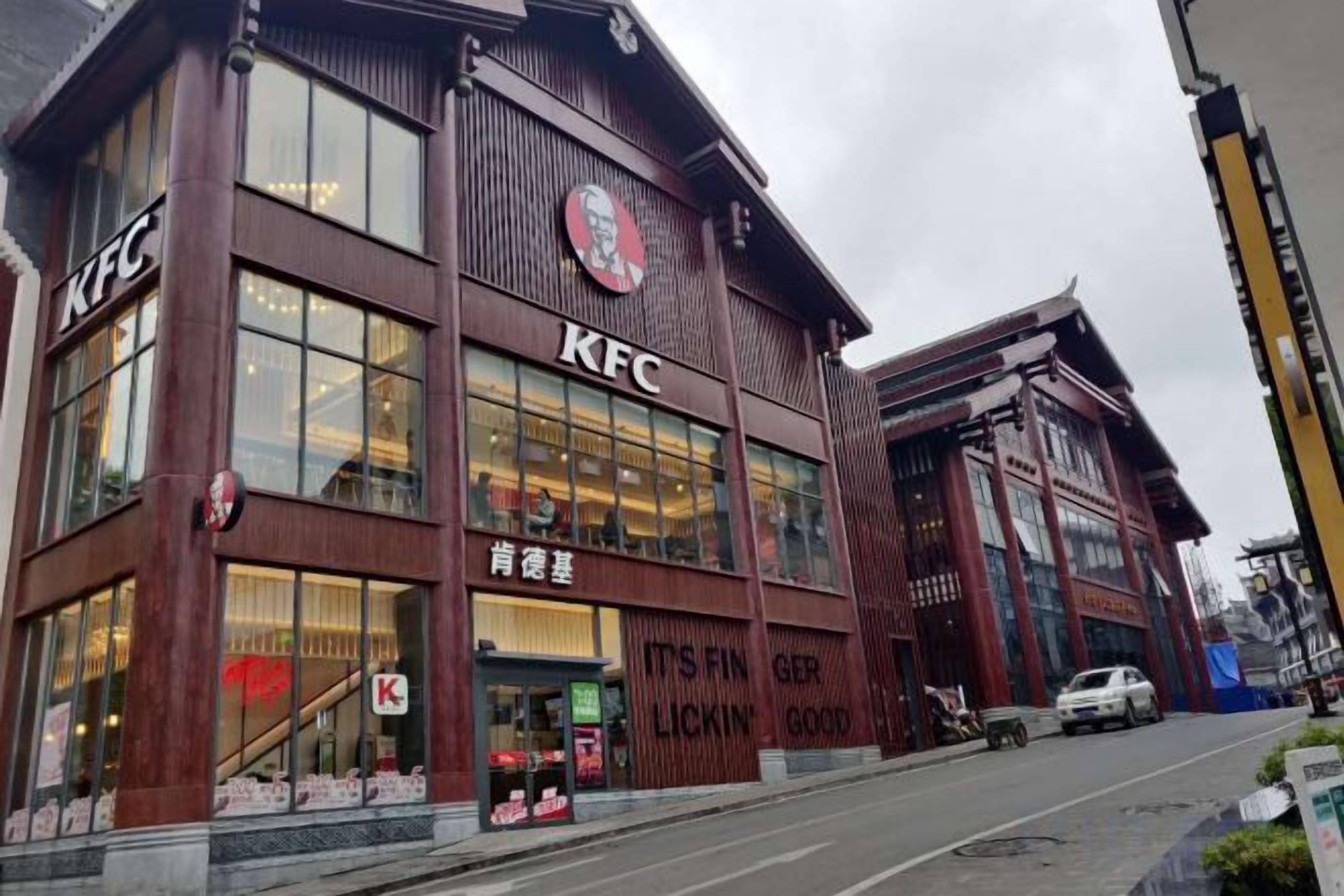 Un restaurante KFC con estilo arquitectónico tradicional, con grandes ventanales y el logotipo de KFC bien visible.