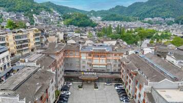Un edificio tradicional con un patio central, rodeado de otras construcciones, y vistas a un paisaje montañoso.